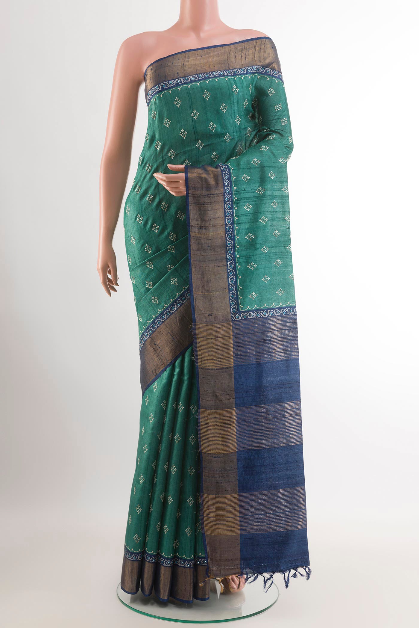 Green Tussar Saree with Thread Butta on the body and Zari Border.  displayed on a mannequin