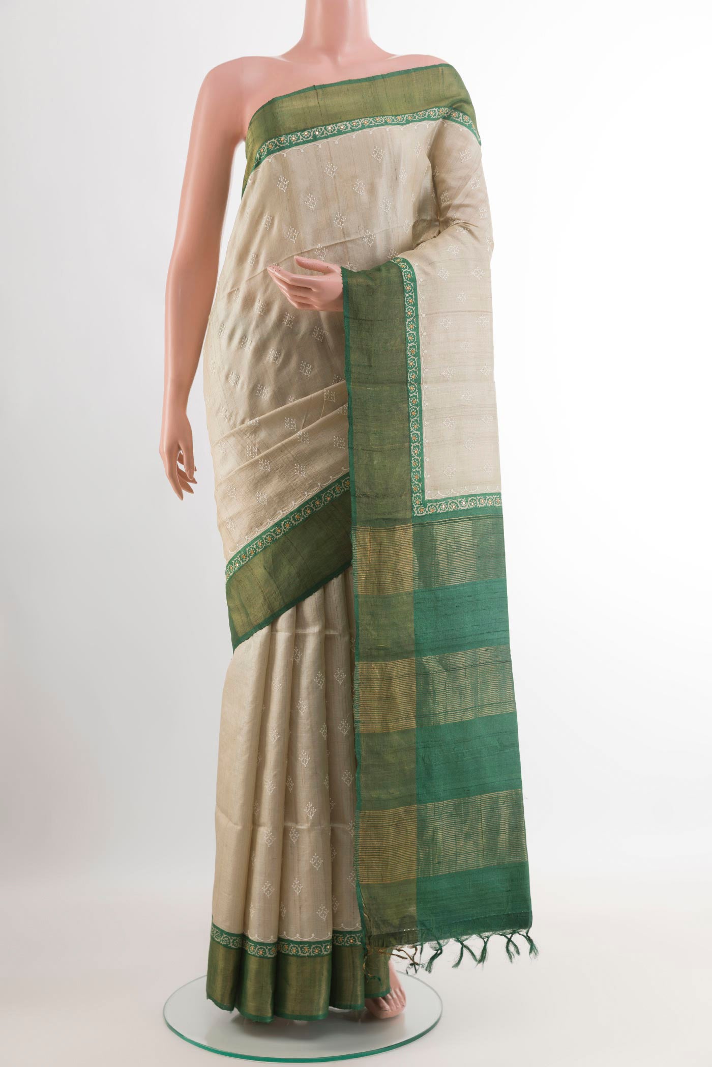 Off White Tussar Saree with Thread Butta on the body and Zari Border.  displayed on a mannequin