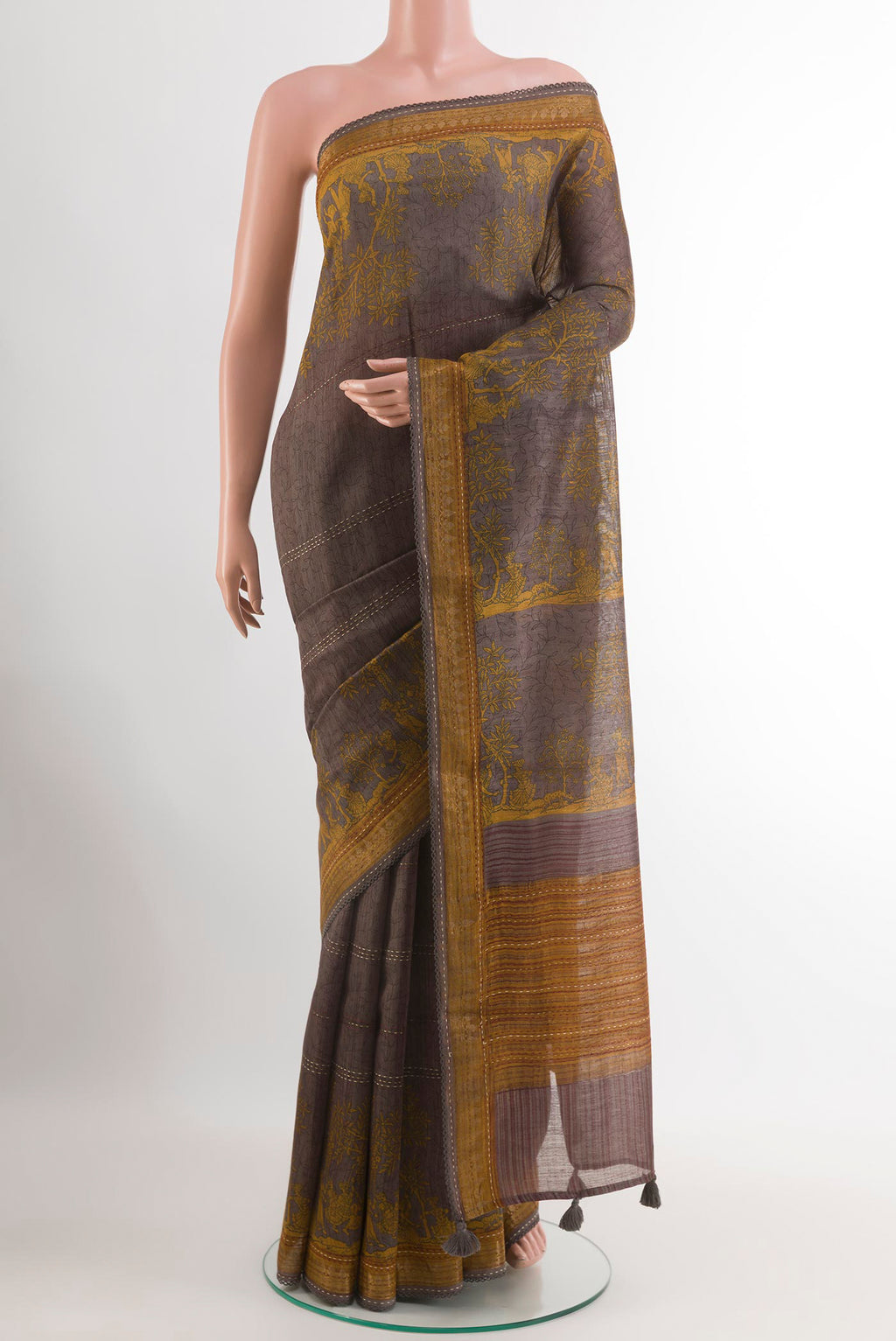 Grey Tussar Saree with Printed design on the body and Zari Border.  displayed on a mannequin