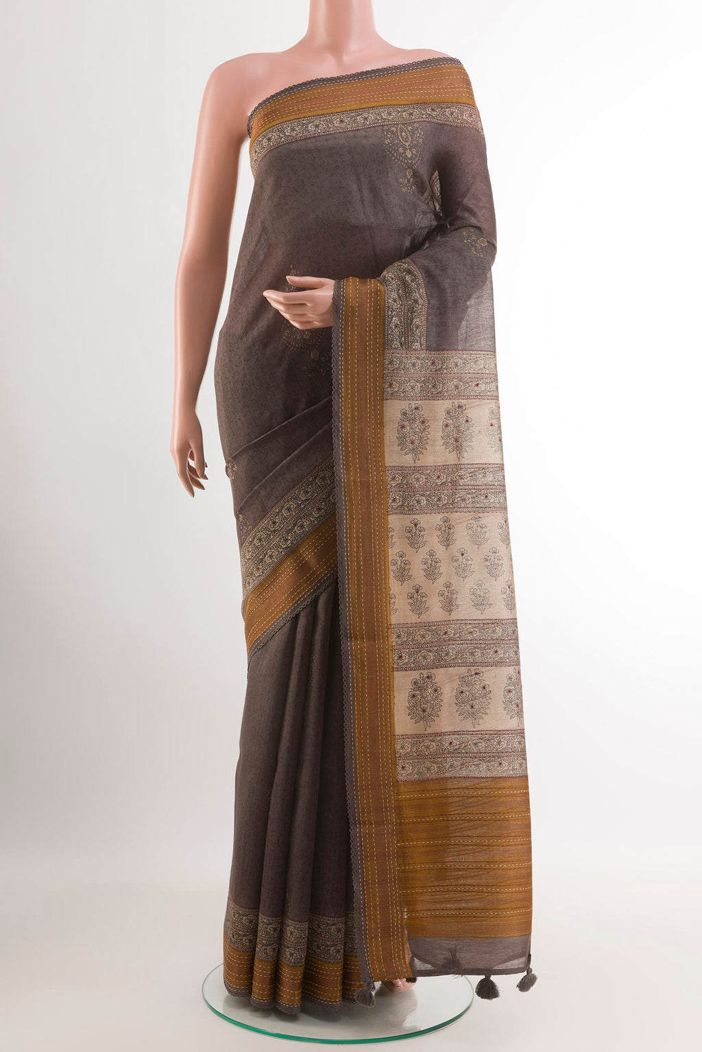 Grey Tussar Saree with Printed design on the body and Zari Border.  displayed on a mannequin