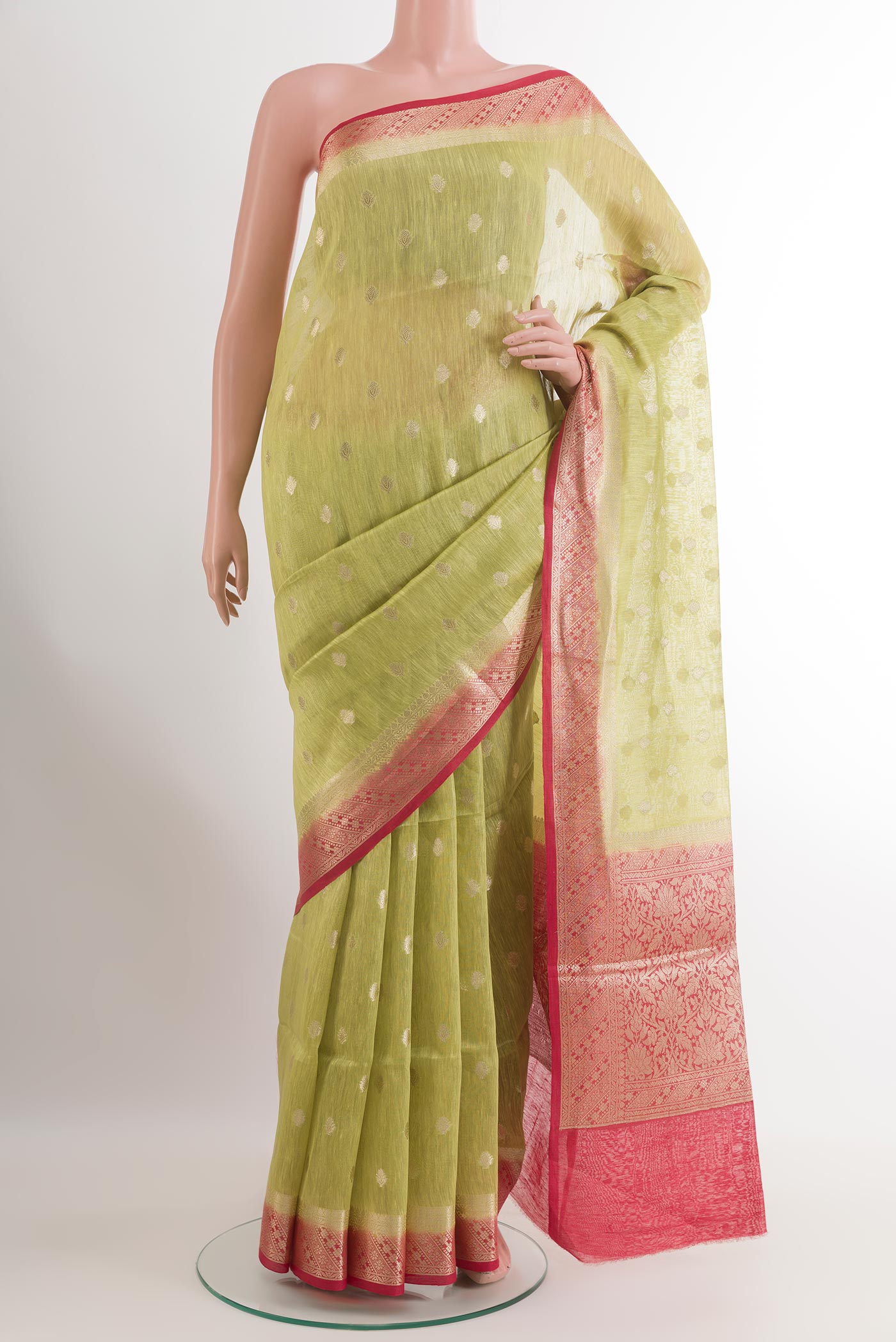 Green Linen Saree with Zari Butta on the body and Zari Border.  displayed on a mannequin