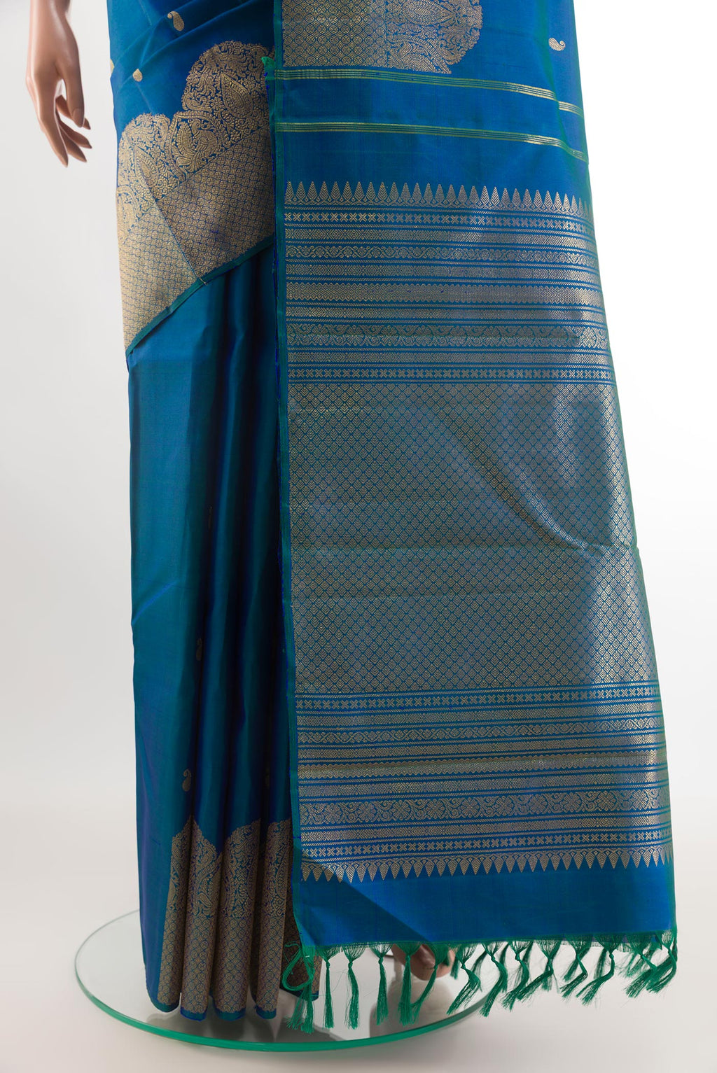 Pleats and pallu of Peacock Blue Kanchipuram Silk Saree with Zari Butta on the body and Zari Border. 