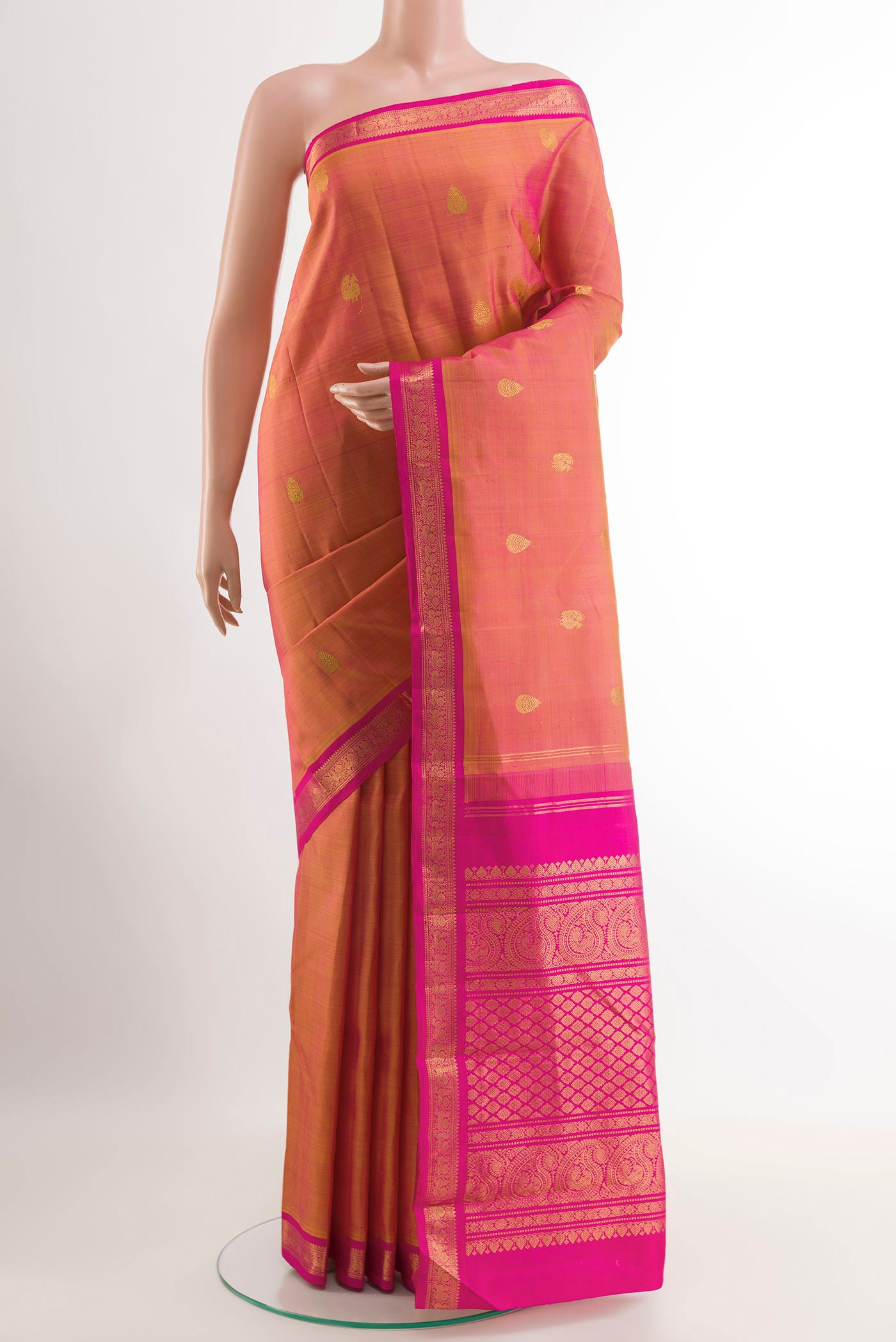 Brick Orange Kanchipuram Silk Saree with Zari Butta on the body and Ganga Jamuna Border.  displayed on a mannequin