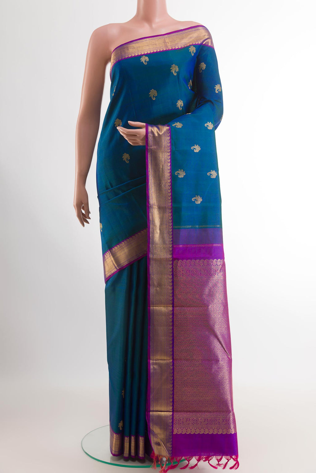 Peacock Blue Kanjivaram Silk Saree with Zari Butta on the body and Zari Border.  displayed on a mannequin