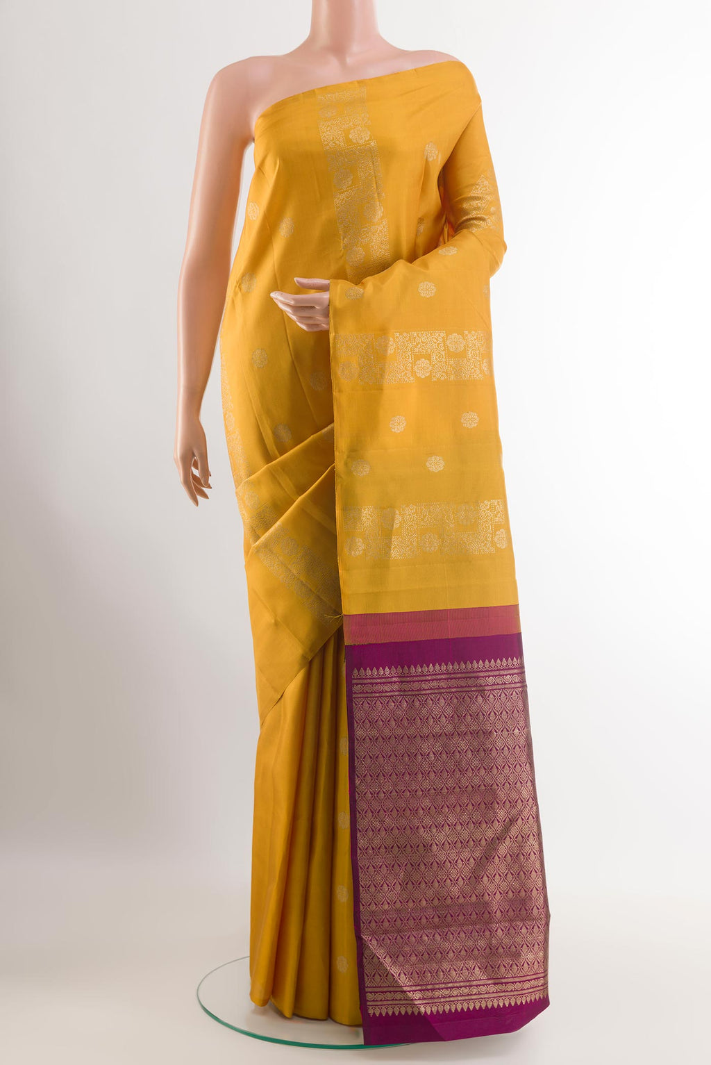 Yellow Kanchipuram Silk Saree with Zari Butta on the body and Zari Border.  displayed on a mannequin