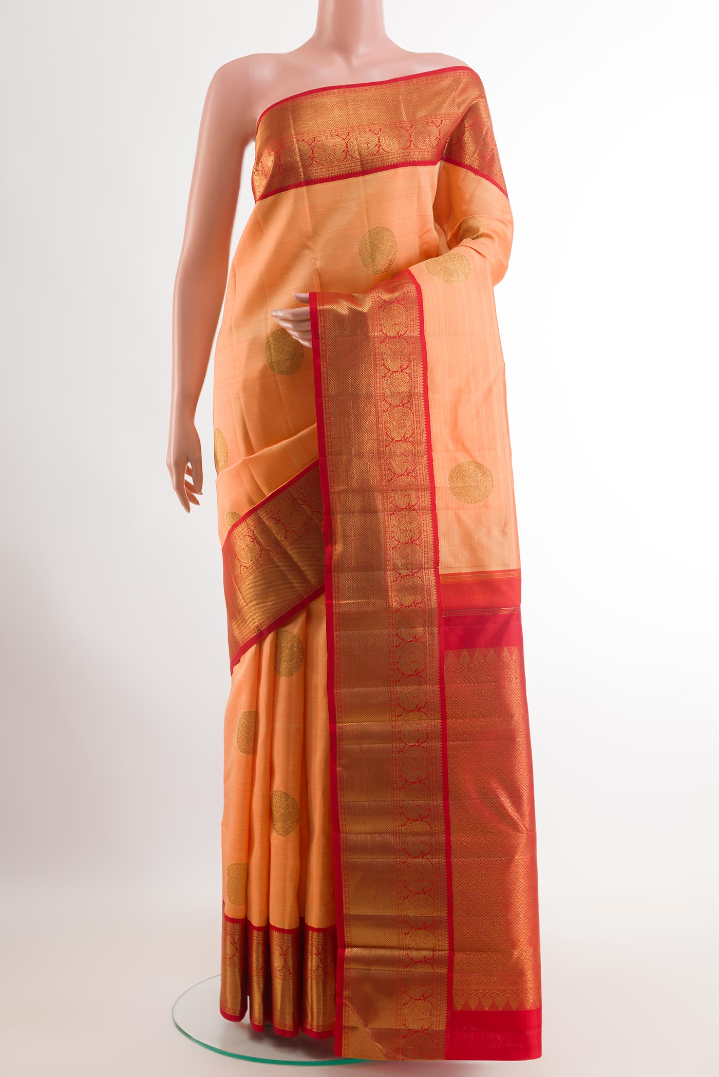Orange Kanchipuram Silk Saree with Zari Butta on the body and Zari Border.  displayed on a mannequin
