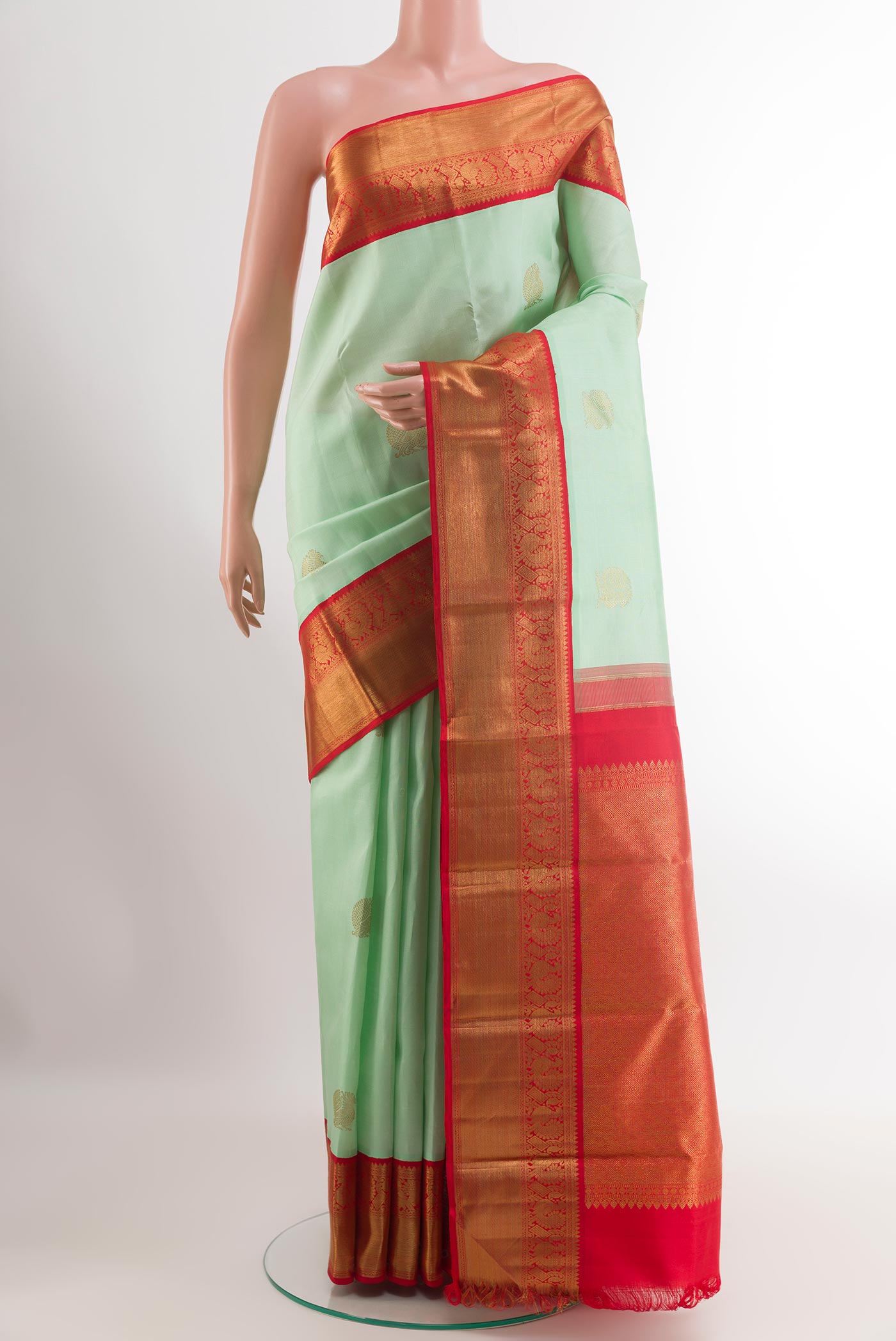 Pista Green Kanchipuram Silk Saree with Zari Butta on the body and Zari Border.  displayed on a mannequin