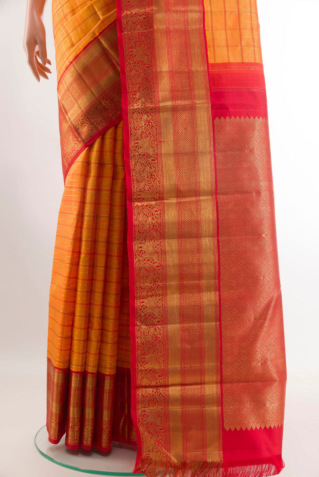 Pleats and pallu of Orange Kanchipuram Silk Saree with Checked design on the body and Ganga Jamuna Border. 
