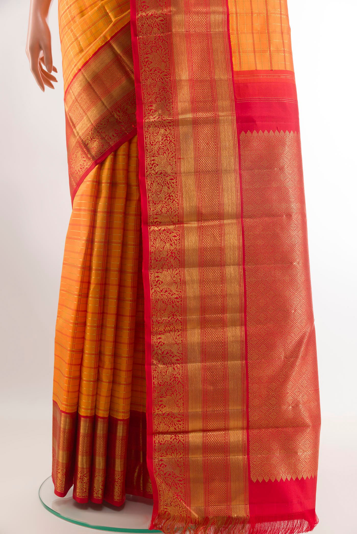 Pleats and pallu of Orange Kanchipuram Silk Saree with Checked design on the body and Ganga Jamuna Border. 