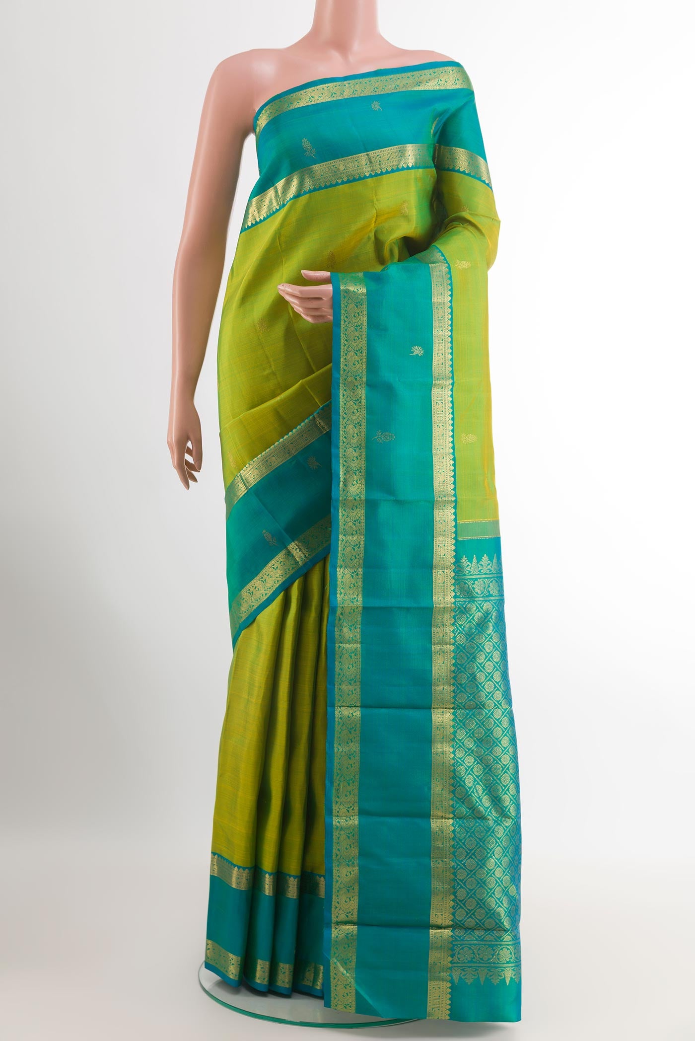 Green Kanjivaram Silk Saree with Zari Butta on the body and Zari Border.  displayed on a mannequin
