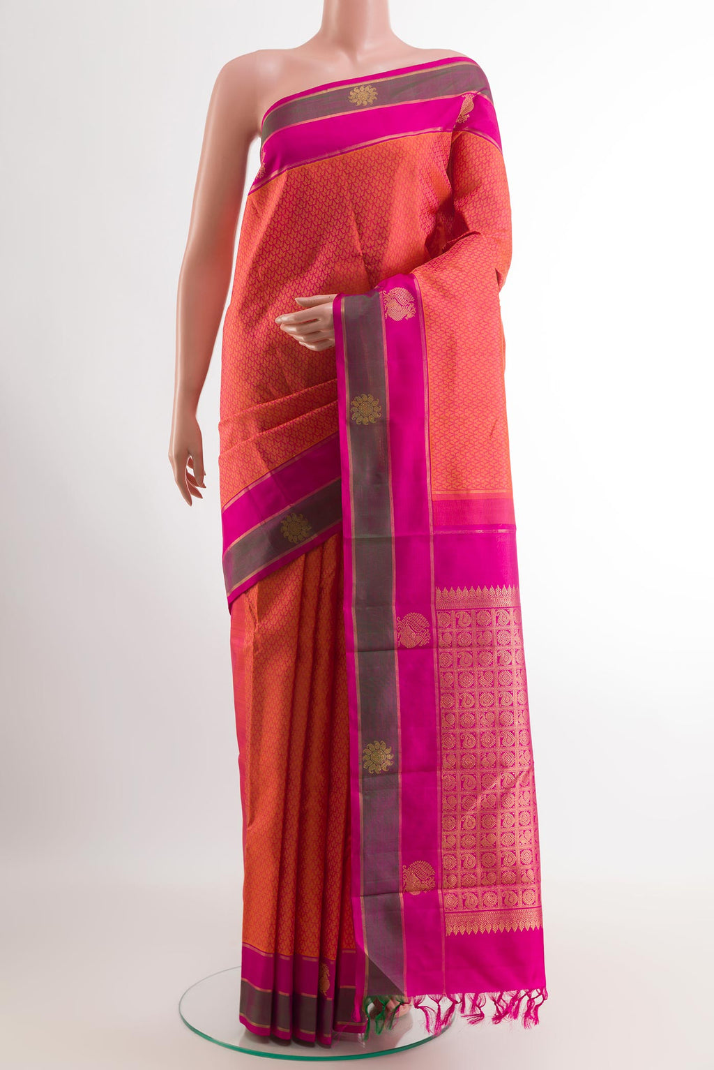 Peach Kanjivaram Silk Saree with Jacquard design on the body and Zari Border.  displayed on a mannequin