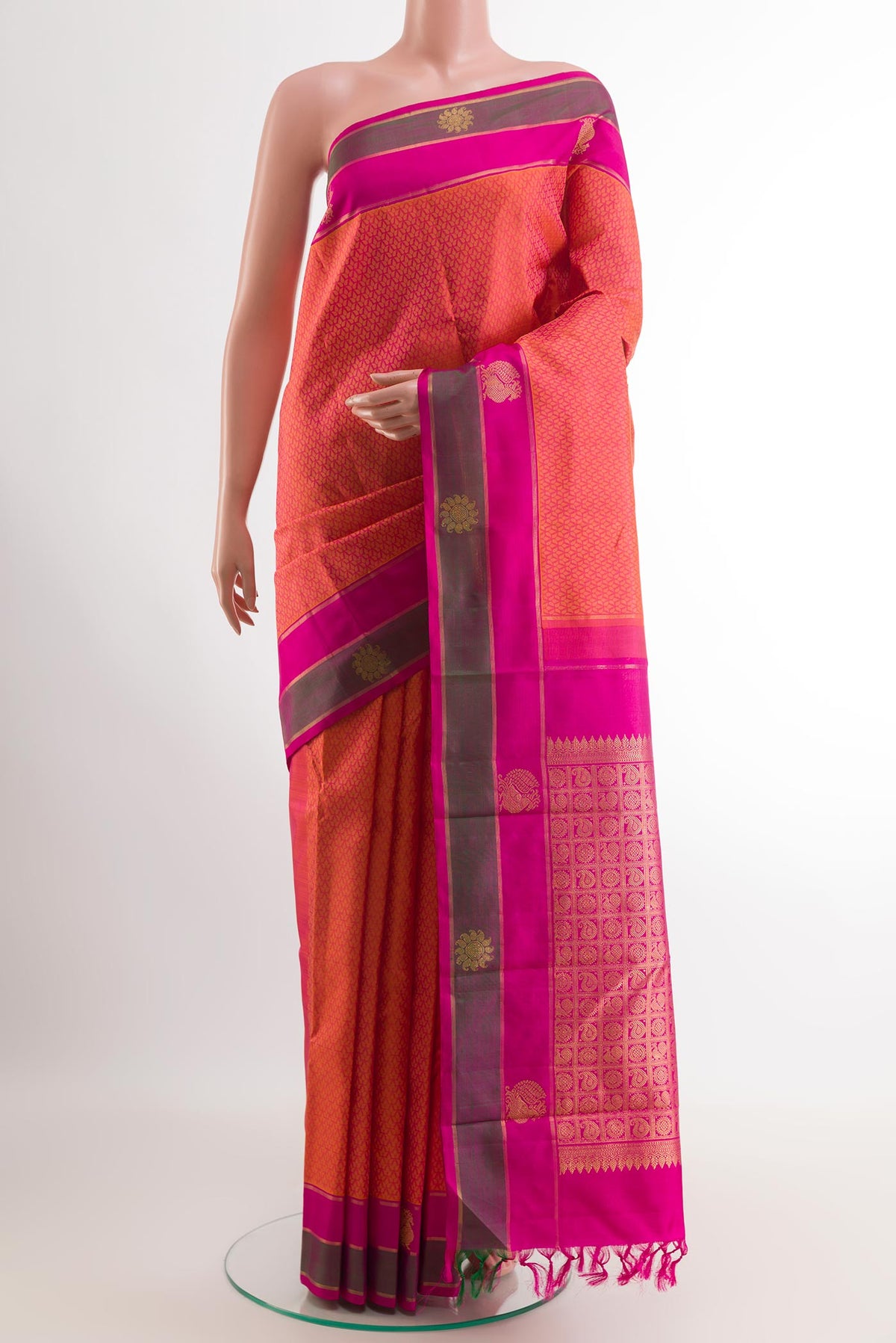 Peach Kanjivaram Silk Saree with Jacquard design on the body and Zari Border.  displayed on a mannequin