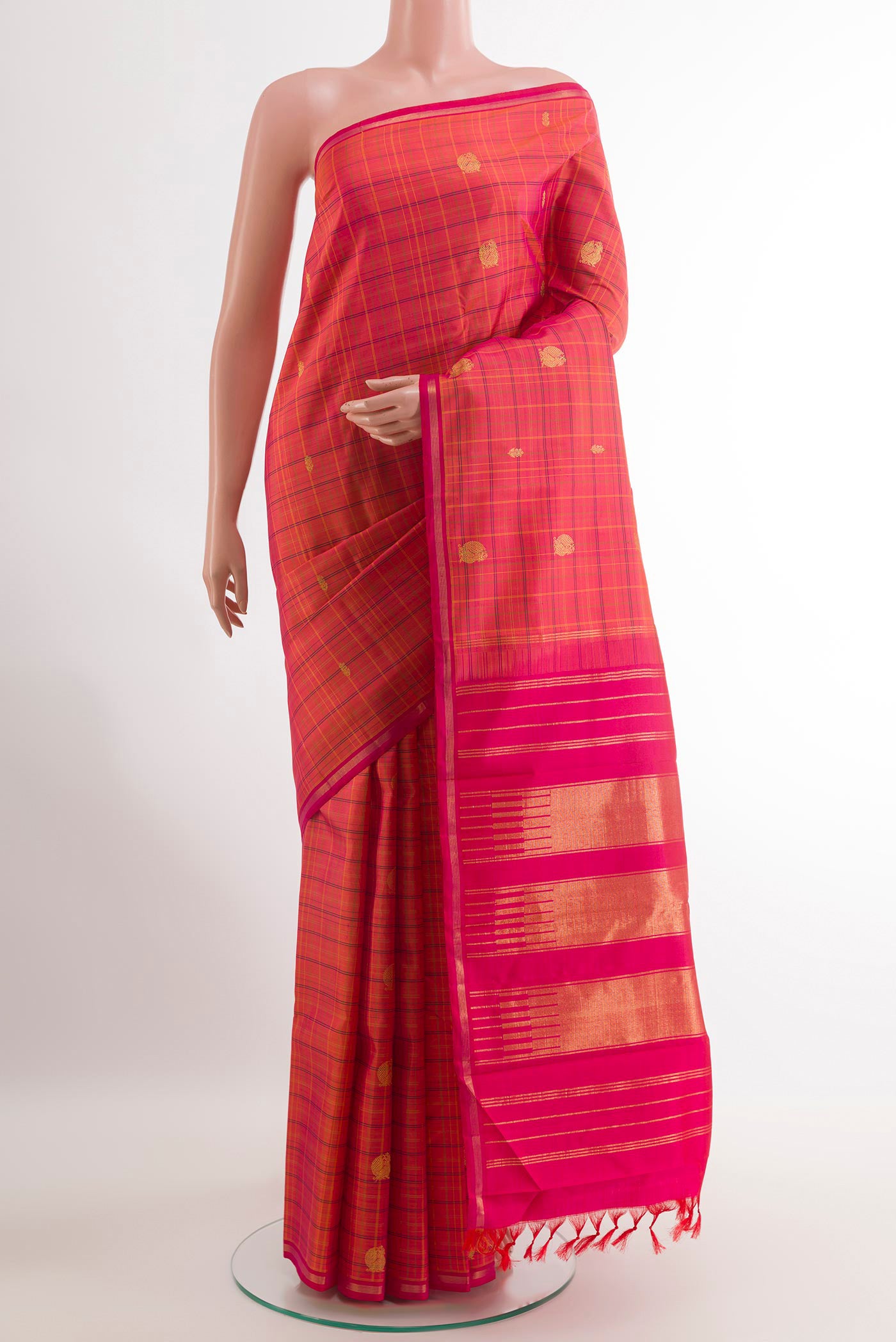 Peach Kanjivaram Silk Saree with Checked design on the body and Zari Border.  displayed on a mannequin