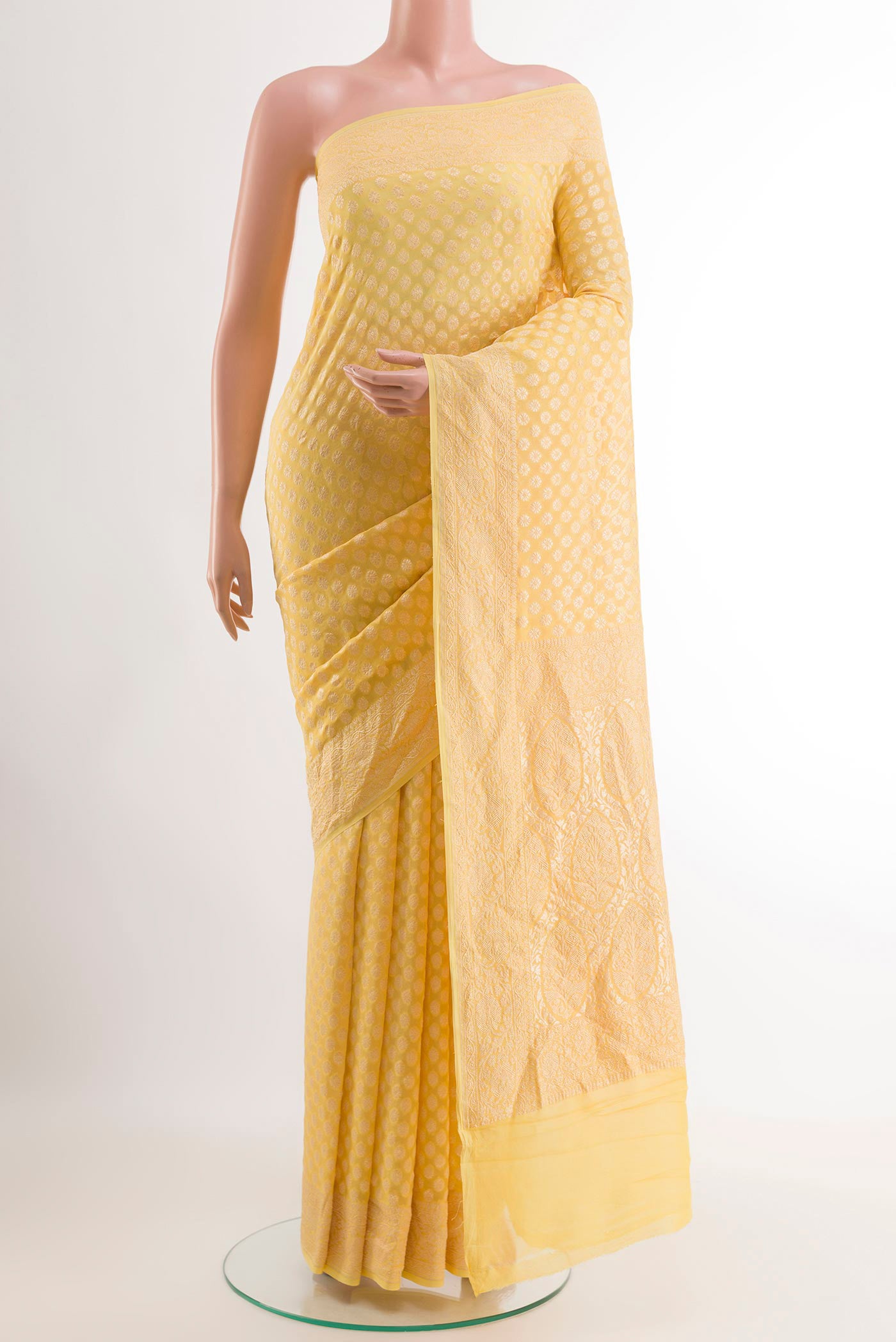 Yellow Banarasi Georgette Saree with Zari Butta on the body and Zari Border.  displayed on a mannequin