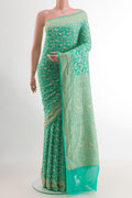 Turquoise Banarasi Georgette Saree with Zari Brocade on the body and Zari Border.  displayed on a mannequin