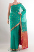 Sea Green Blended Kora Cotton Saree with Zari Butta on the body and Zari Border.  displayed on a mannequin