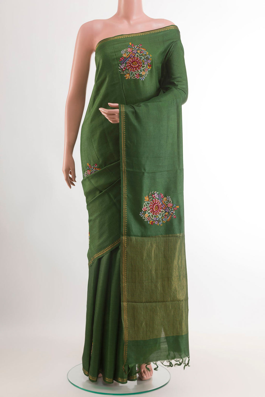 Green Tussar Saree with Embroidery on the body and Zari Border.  displayed on a mannequin