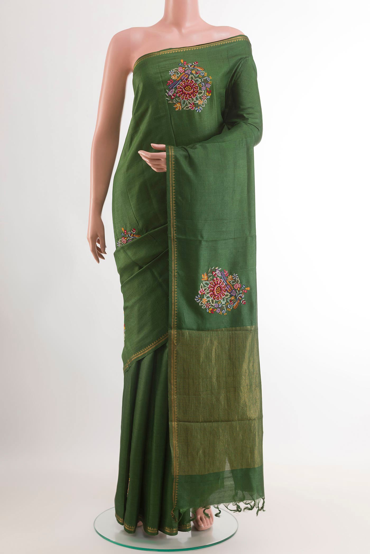 Green Tussar Saree with Embroidery on the body and Zari Border.  displayed on a mannequin