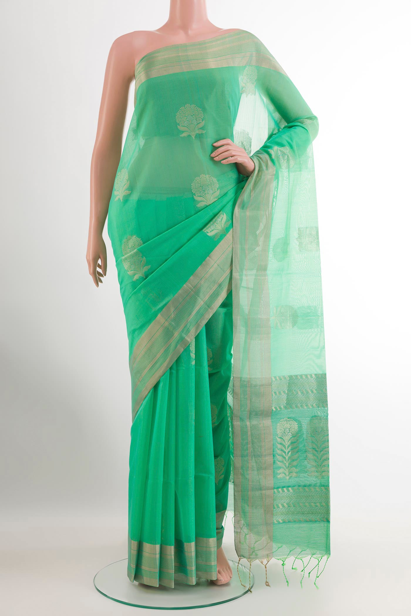 Green Blended Kora Cotton Saree with Zari Butta on the body and Zari Border.  displayed on a mannequin