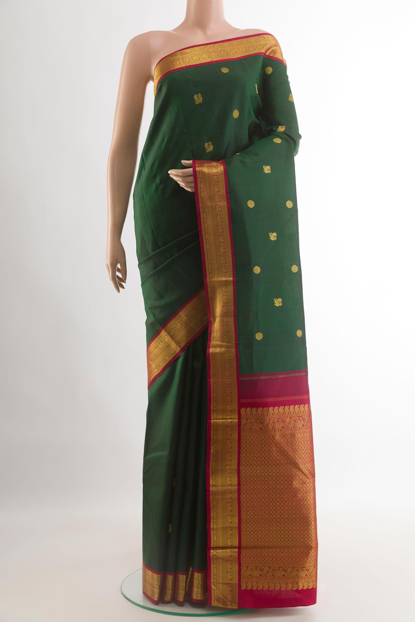 Bottle Green Kanjivaram Silk Saree with Zari Butta on the body and Zari Border.  displayed on a mannequin