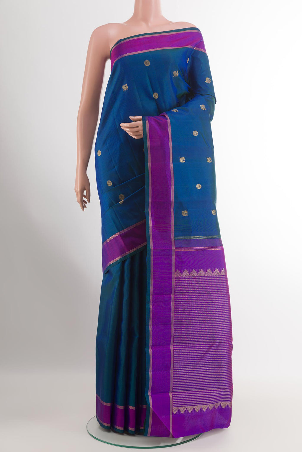 Peacock Blue Kanchipuram Silk Saree with Zari Butta on the body and Zari Border.  displayed on a mannequin