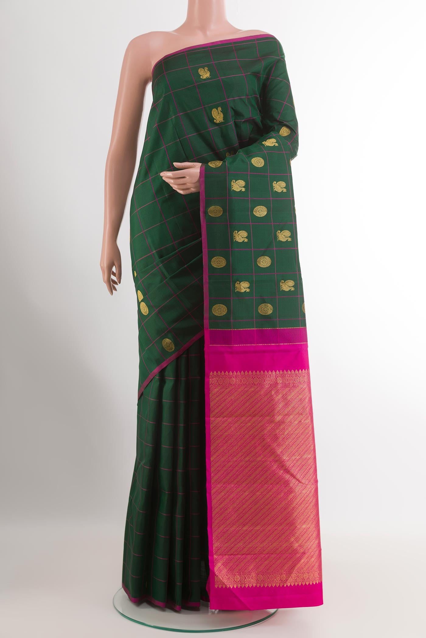 Green Kanchipuram Silk Saree with Zari Butta on the body and Zari Border.  displayed on a mannequin