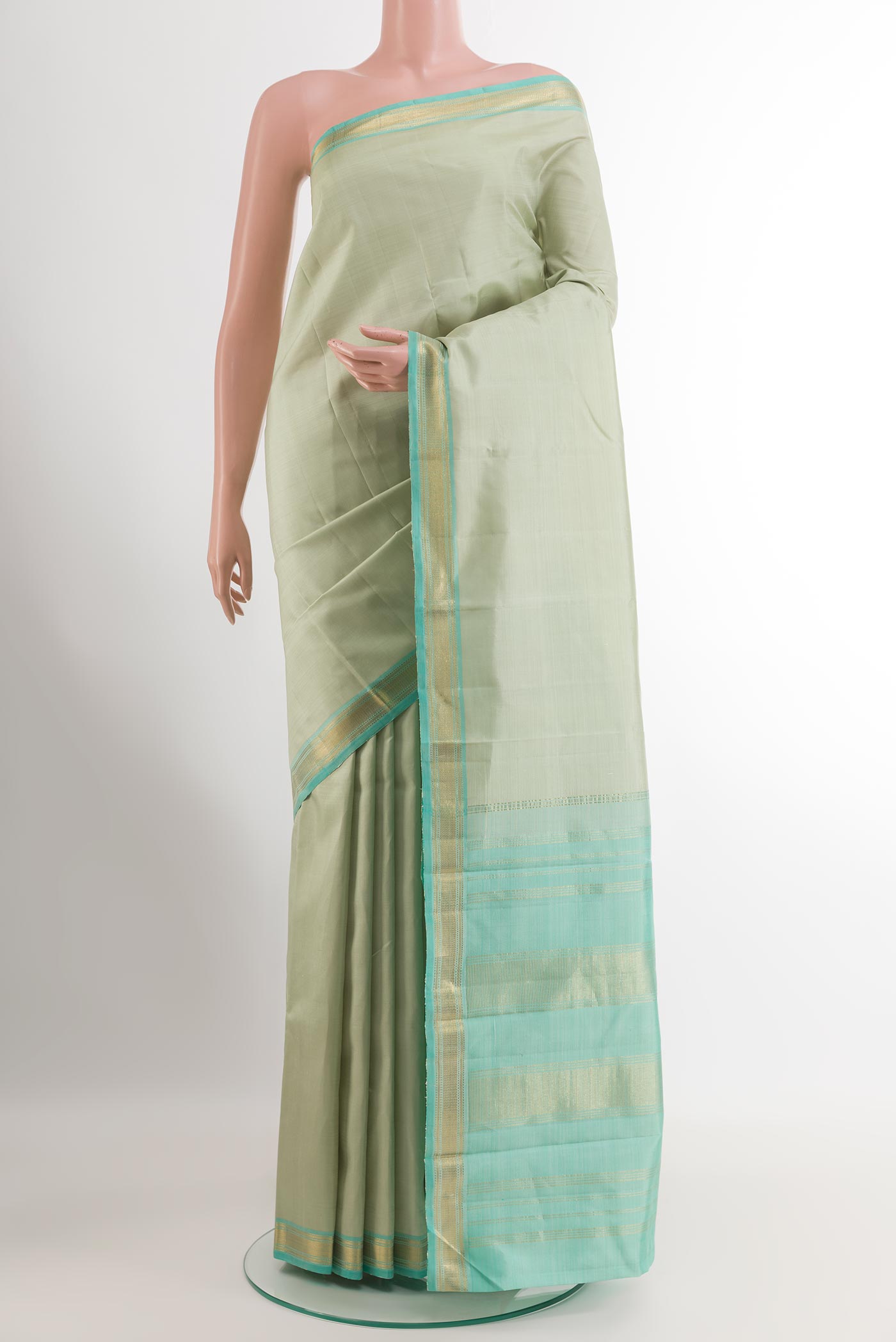 Mint Green Kanjivaram Silk Saree with Plain Body and Zari Border.  displayed on a mannequin