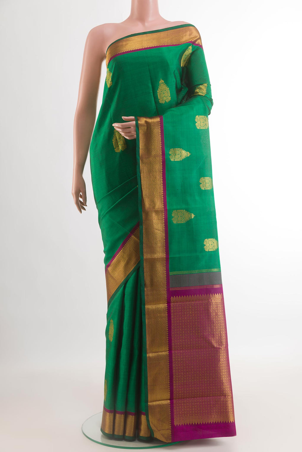 Green Kanchipuram Silk Saree with Zari Butta on the body and Zari Border.  displayed on a mannequin