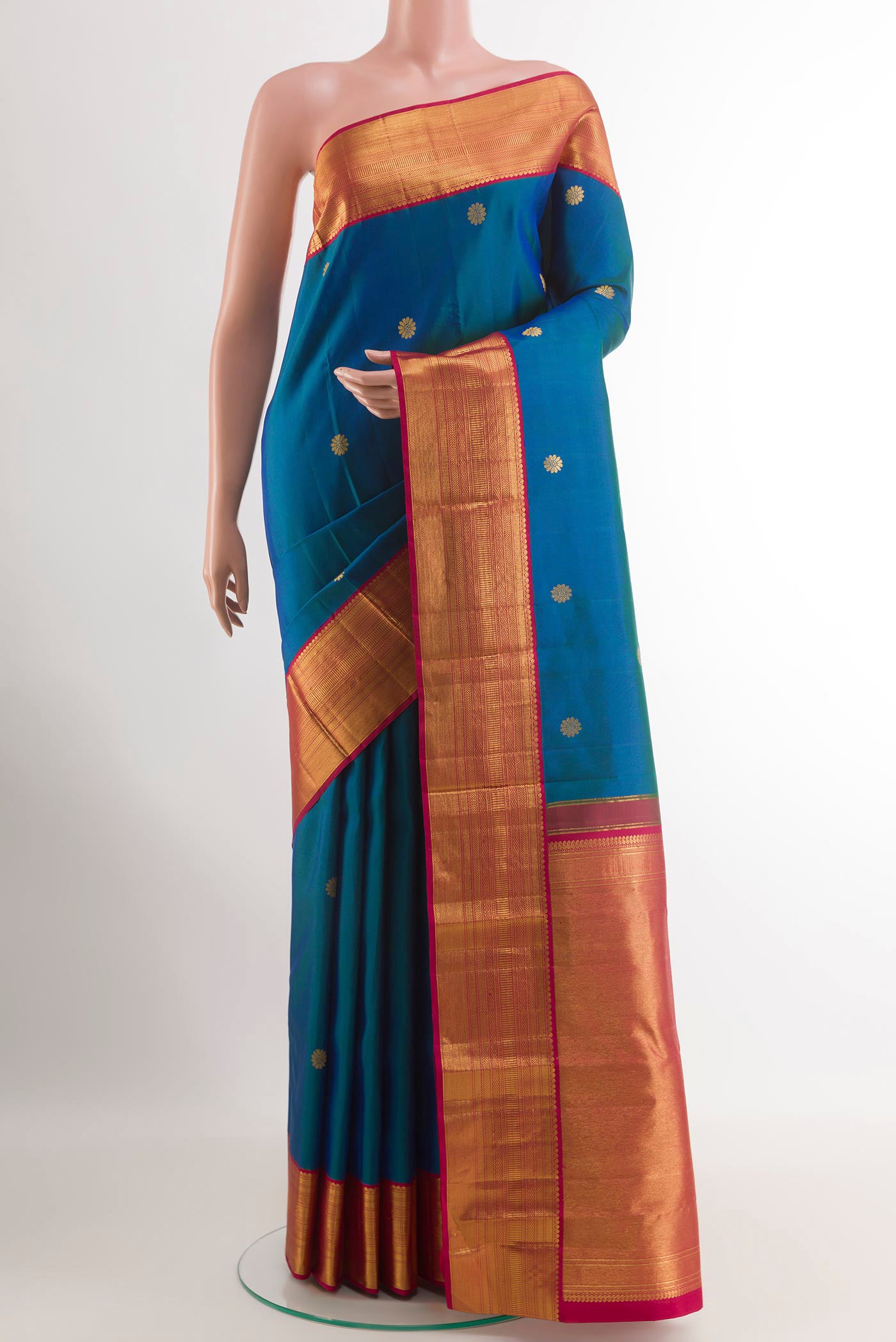 Peacock Blue Kanjivaram Silk Saree with Zari Butta on the body and Zari Border.  displayed on a mannequin