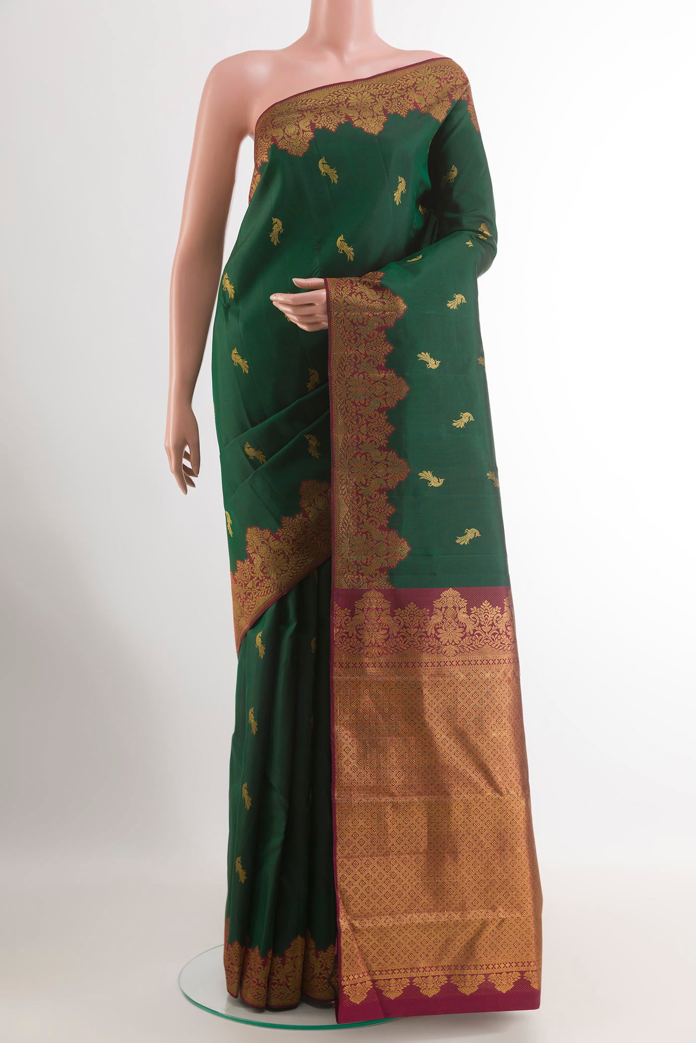 Bottle Green Kanchipuram Silk Saree with Zari Butta on the body and Zari Border.  displayed on a mannequin