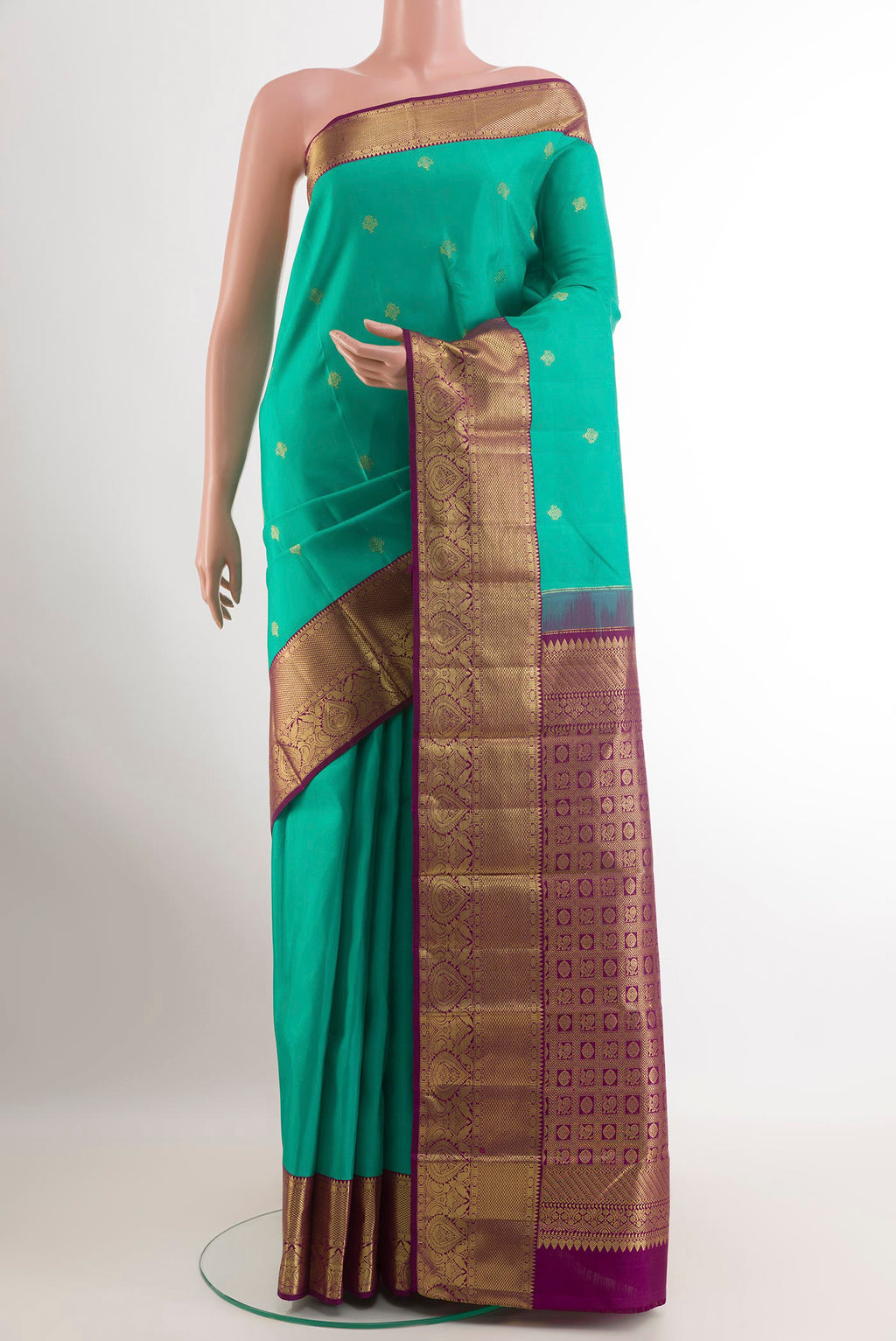 Green Kanjivaram Silk Saree with Zari Butta on the body and Zari Border.  displayed on a mannequin