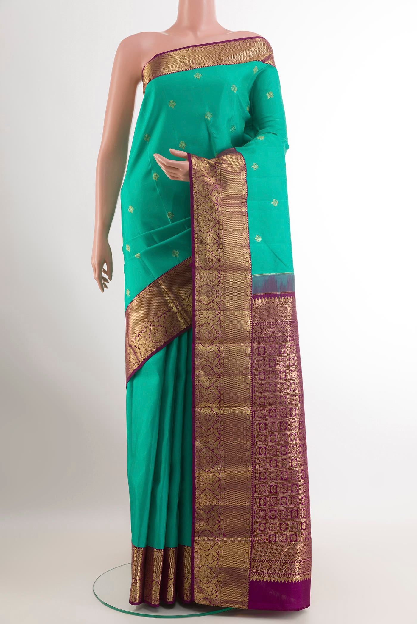 Green Kanjivaram Silk Saree with Zari Butta on the body and Zari Border.  displayed on a mannequin