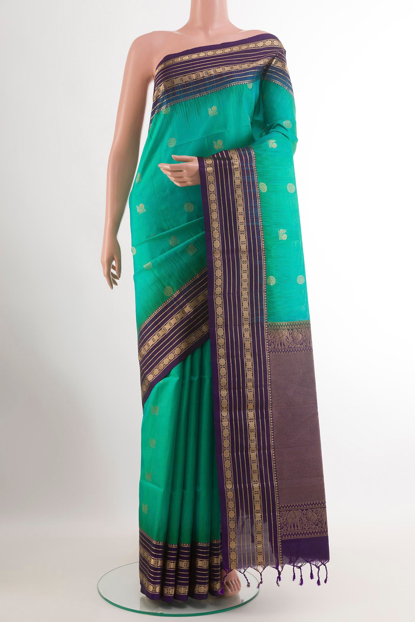 Green Soft Silk Saree with Zari Butta on the body and Zari Border.  displayed on a mannequin