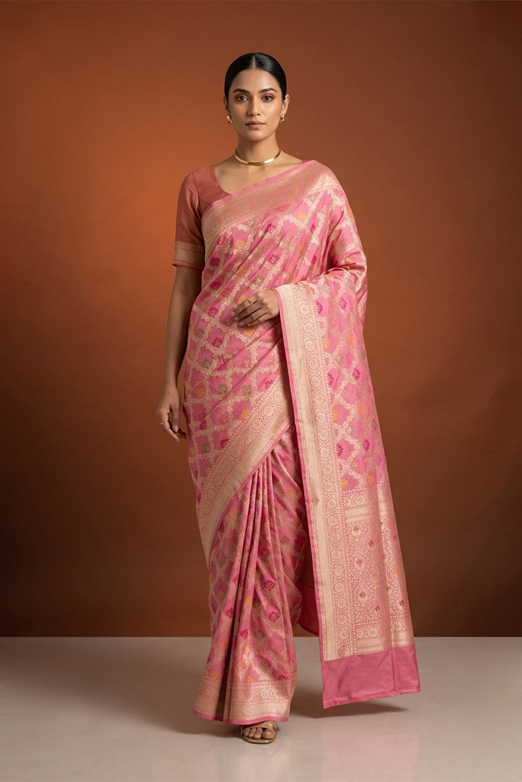 Model wearing a Pink Banarasi Silk Saree with Zari Brocade on the body and Zari Border.