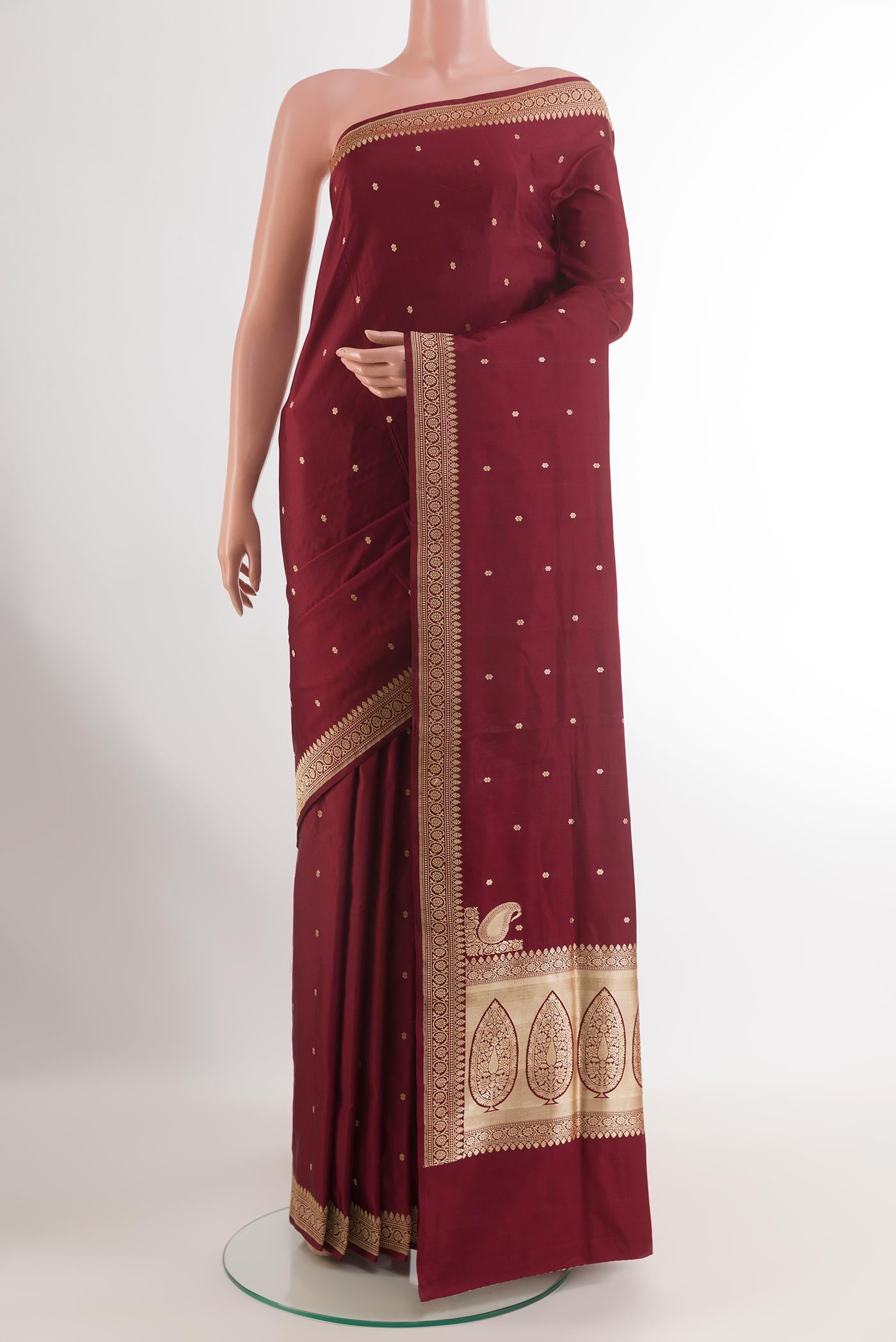 Maroon Banarasi Silk Saree with Zari Butta on the body and Zari Border.  displayed on a mannequin
