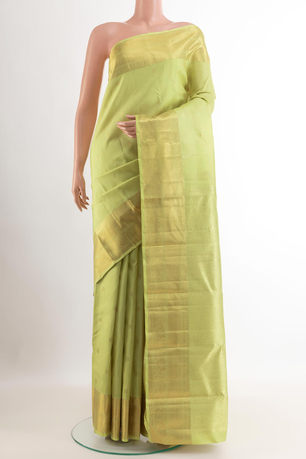 Green Kanchipuram Silk Saree with Zari Butta on the body and Zari Border.  displayed on a mannequin