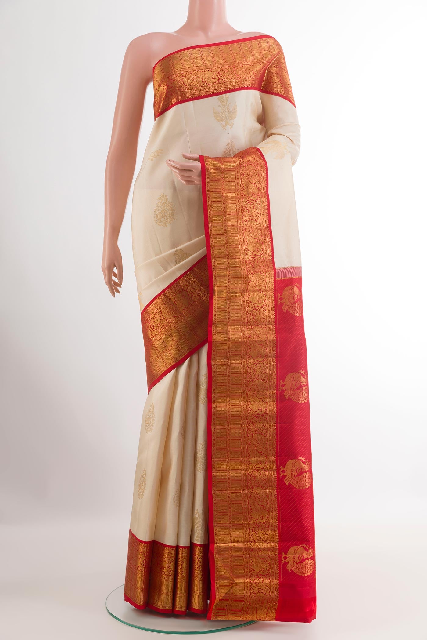 Off White Kanjivaram Silk Saree with Zari Butta on the body and Zari Border.  displayed on a mannequin