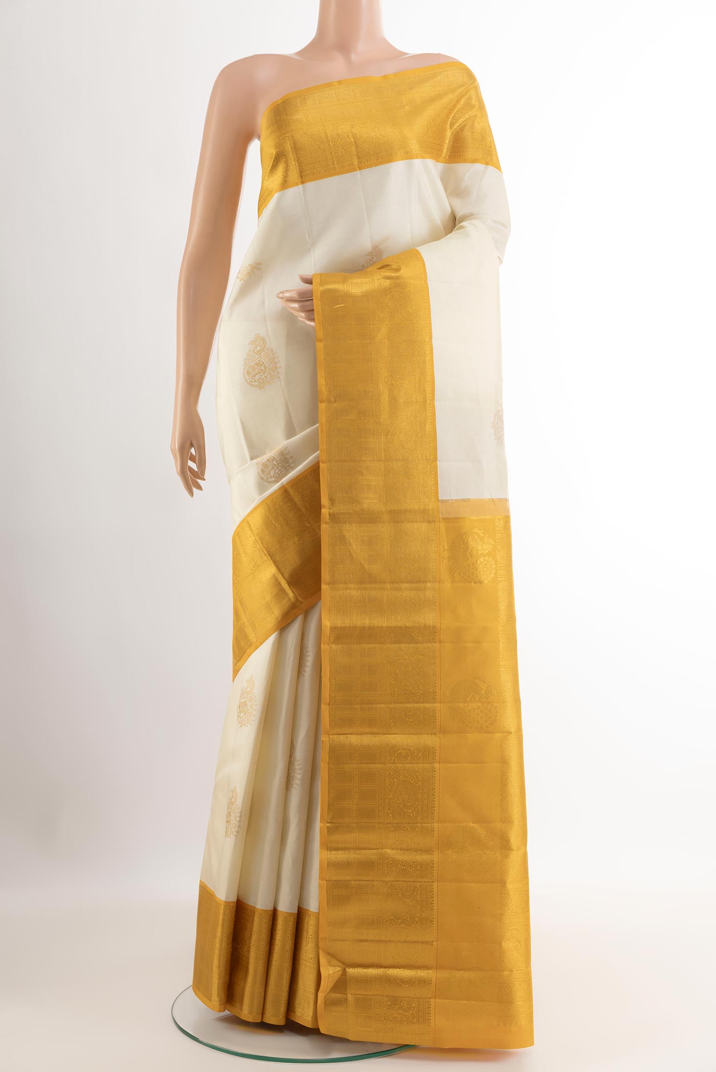 Off White Kanjivaram Silk Saree with Zari Butta on the body and Zari Border.  displayed on a mannequin