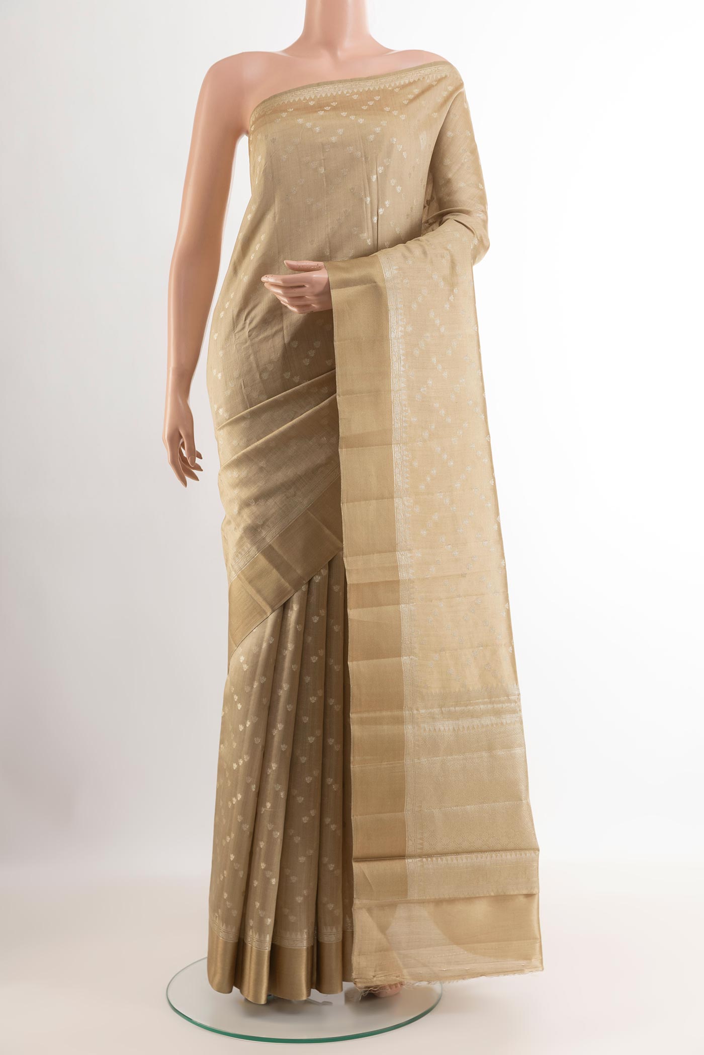 Beige Tussar Silk Saree with Zari Butta on the body and Zari Border.  displayed on a mannequin