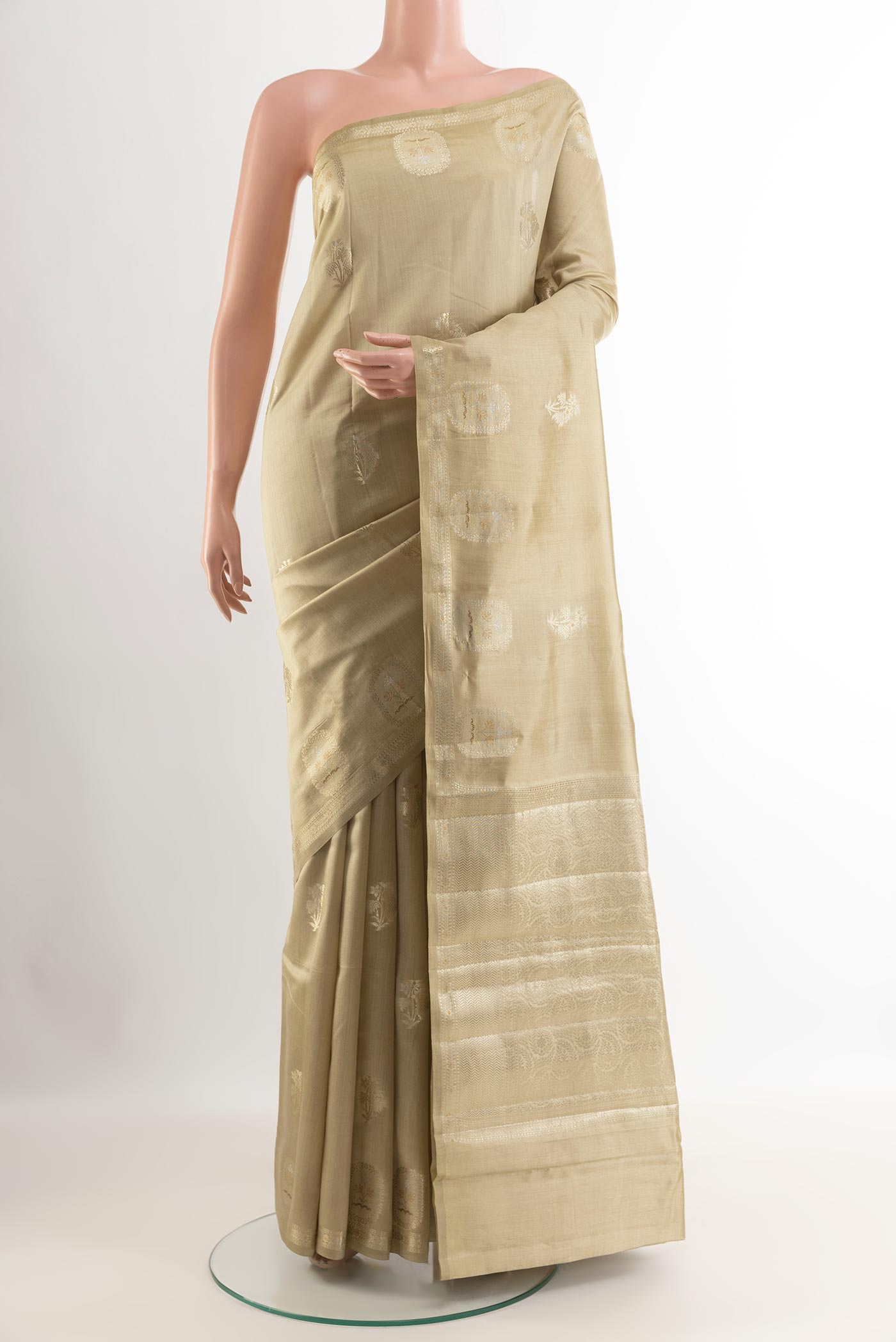 Beige Tussar Silk Saree with Zari Butta on the body and Zari Border.  displayed on a mannequin