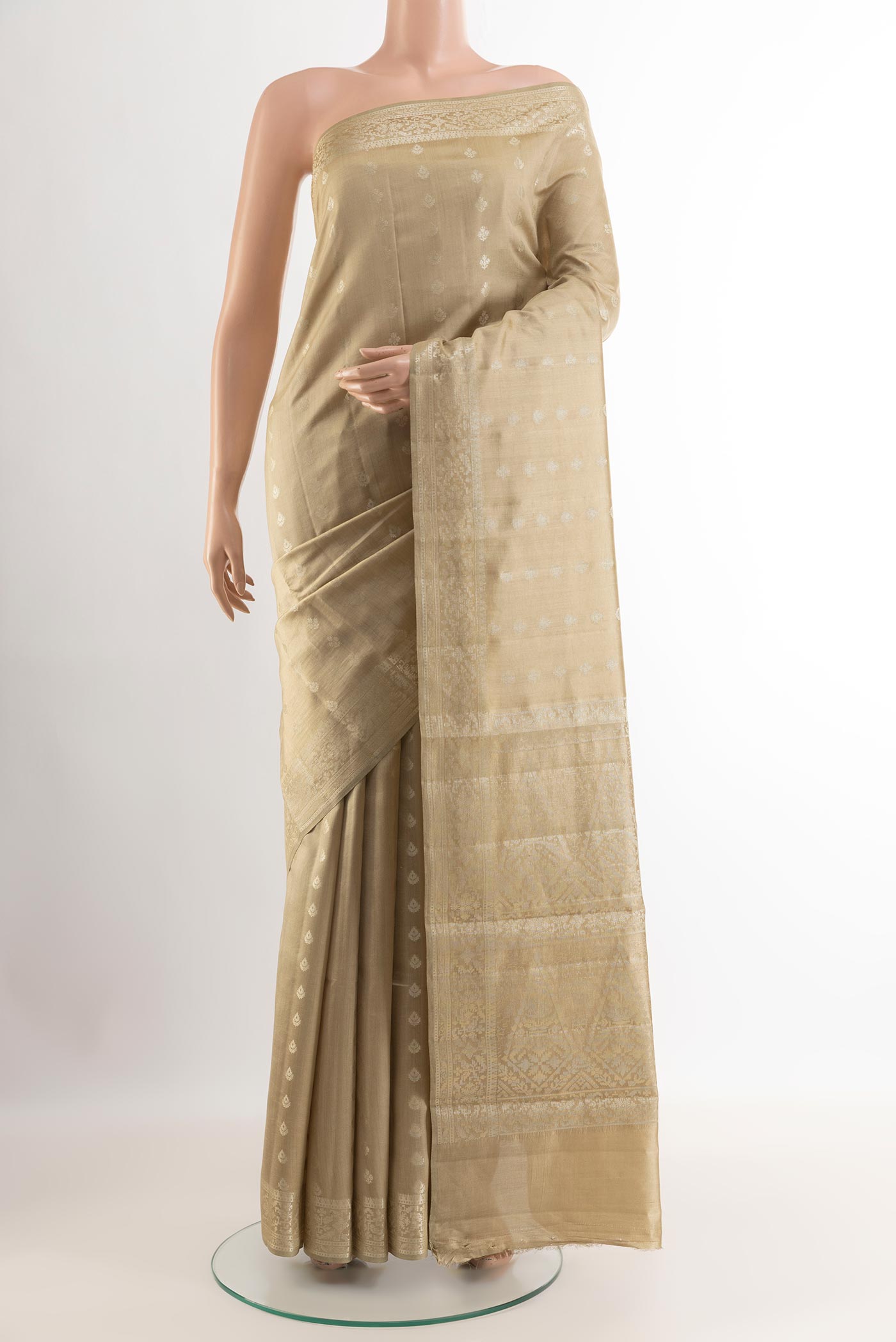 Beige Tussar Silk Saree with Zari Butta on the body and Zari Border.  displayed on a mannequin