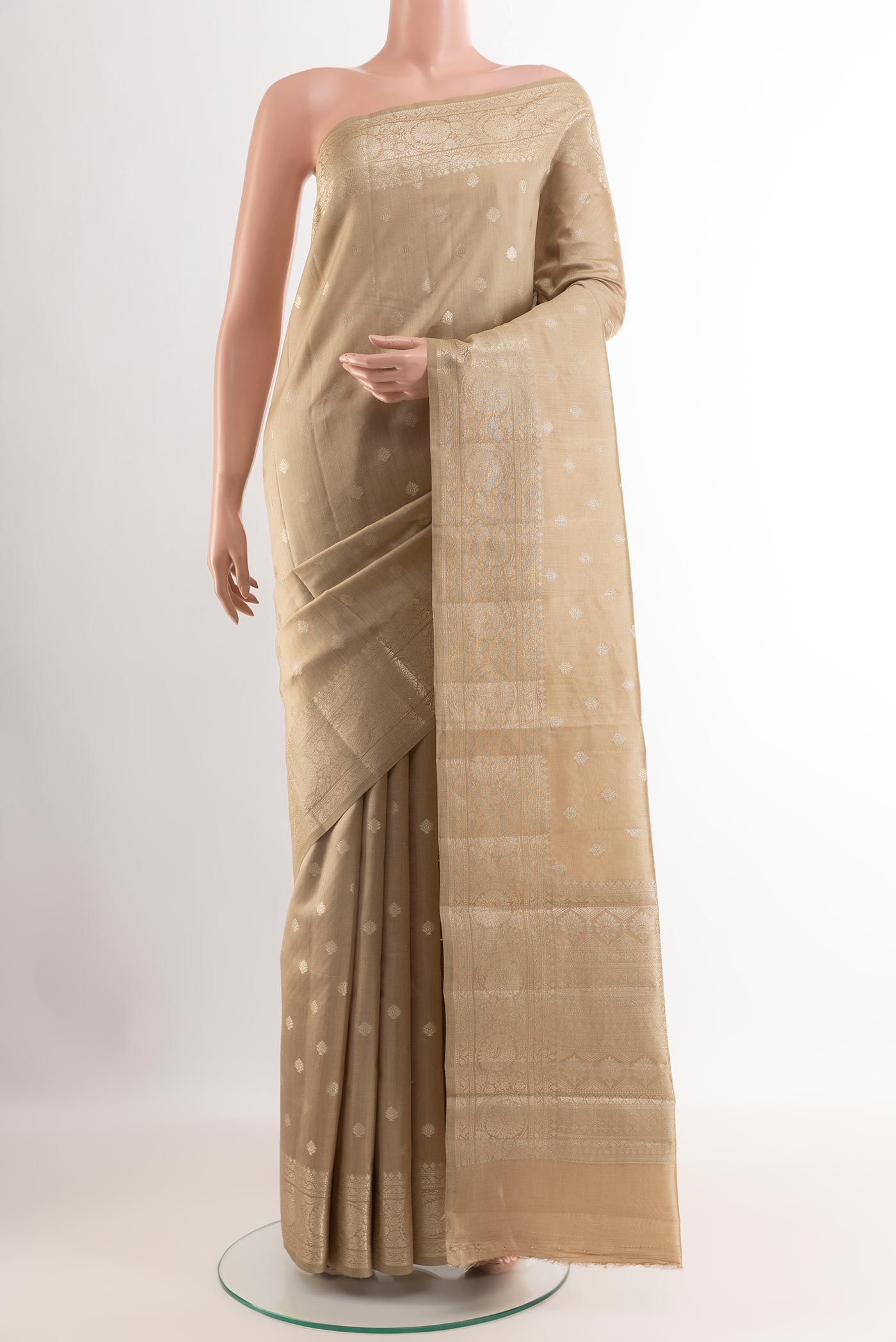 Beige Tussar Silk Saree with Zari Butta on the body and Zari Border.  displayed on a mannequin