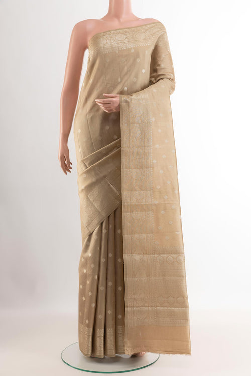 Beige Tussar Silk Saree with Zari Butta on the body and Zari Border.  displayed on a mannequin