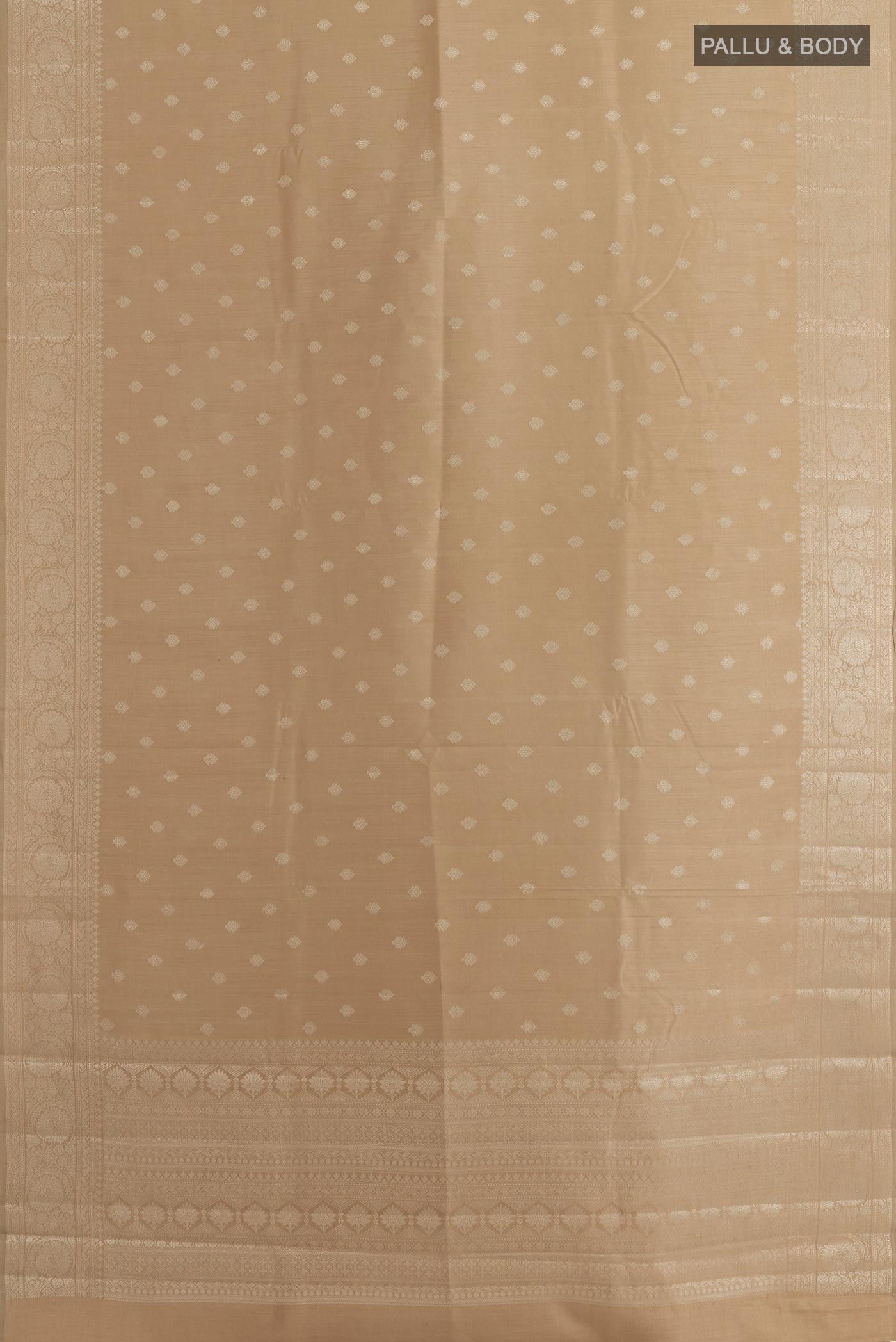 Flat view of Beige Tussar Silk Saree with Zari Butta on the body and Zari Border. 