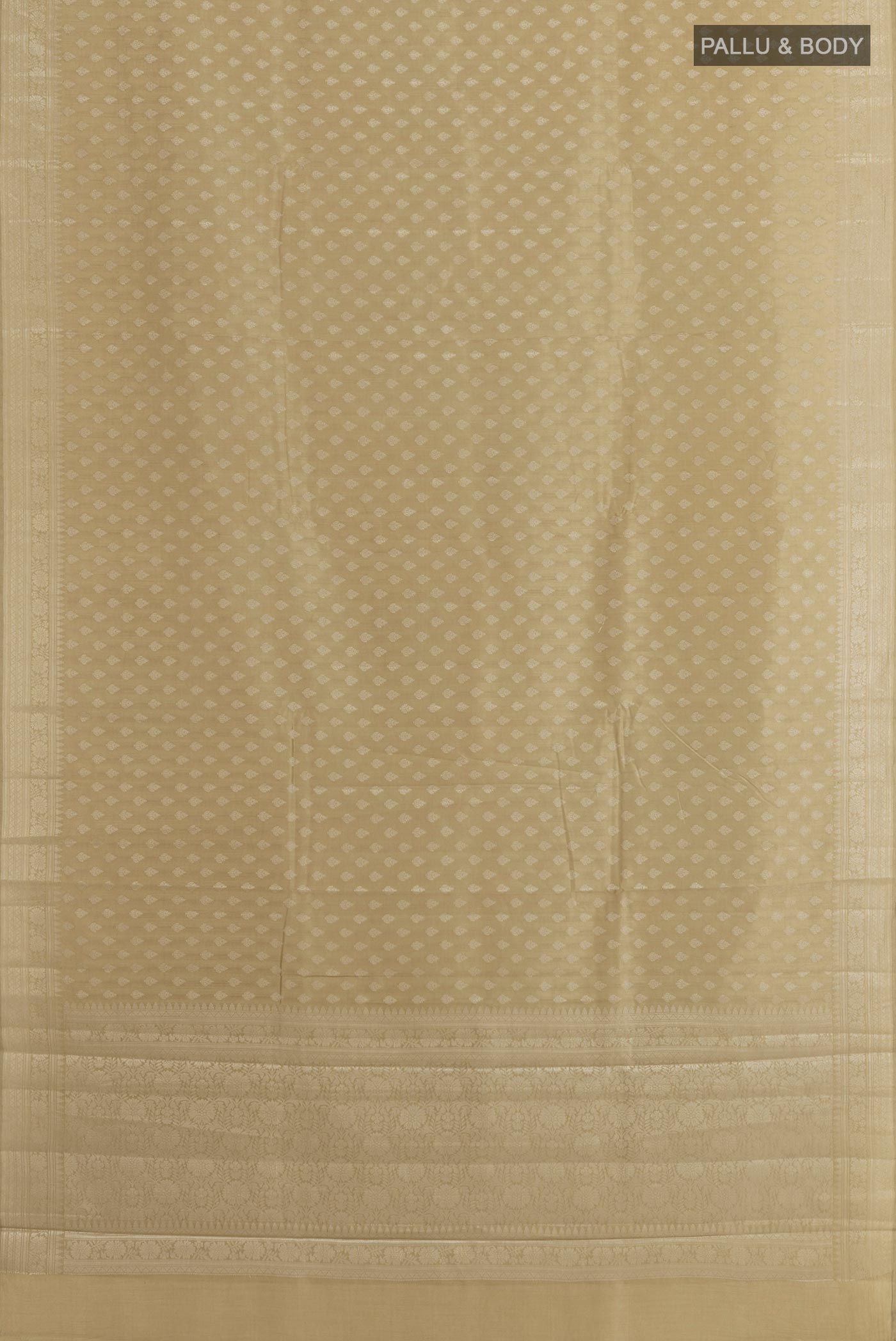 Flat view of Beige Tussar Silk Saree with Zari Butta on the body and Zari Border. 