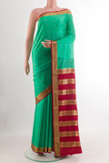 Green Mysore Silk Saree with Zari Butta on the body and Zari Border.  displayed on a mannequin