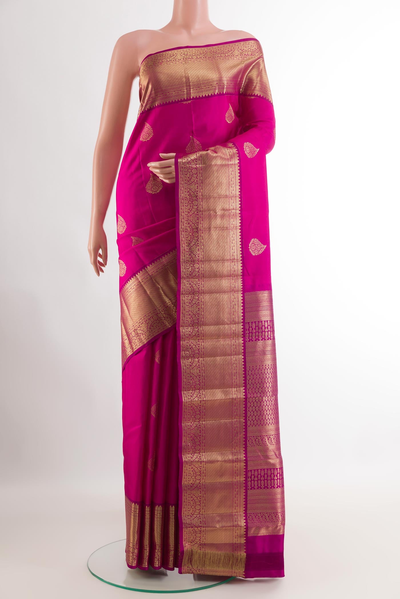 Rani Pink Kanchipuram Silk Saree with Zari Butta on the body and Zari Border.  displayed on a mannequin