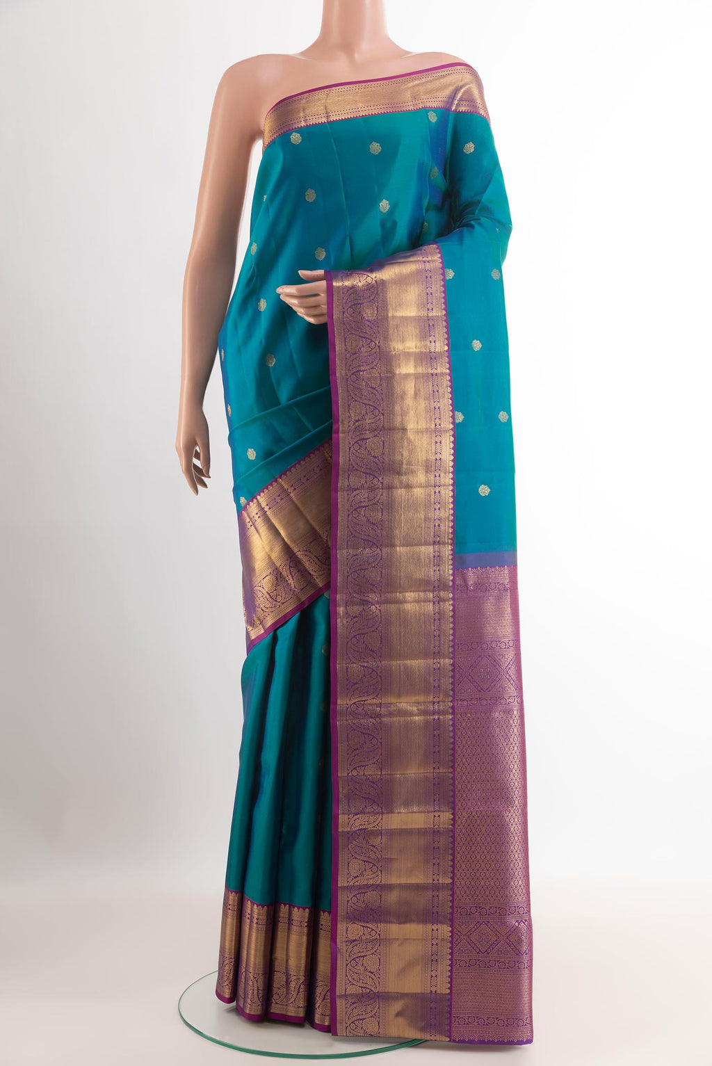 Peacock Blue Kanchipuram Silk Saree with Zari Butta on the body and Zari Border.  displayed on a mannequin