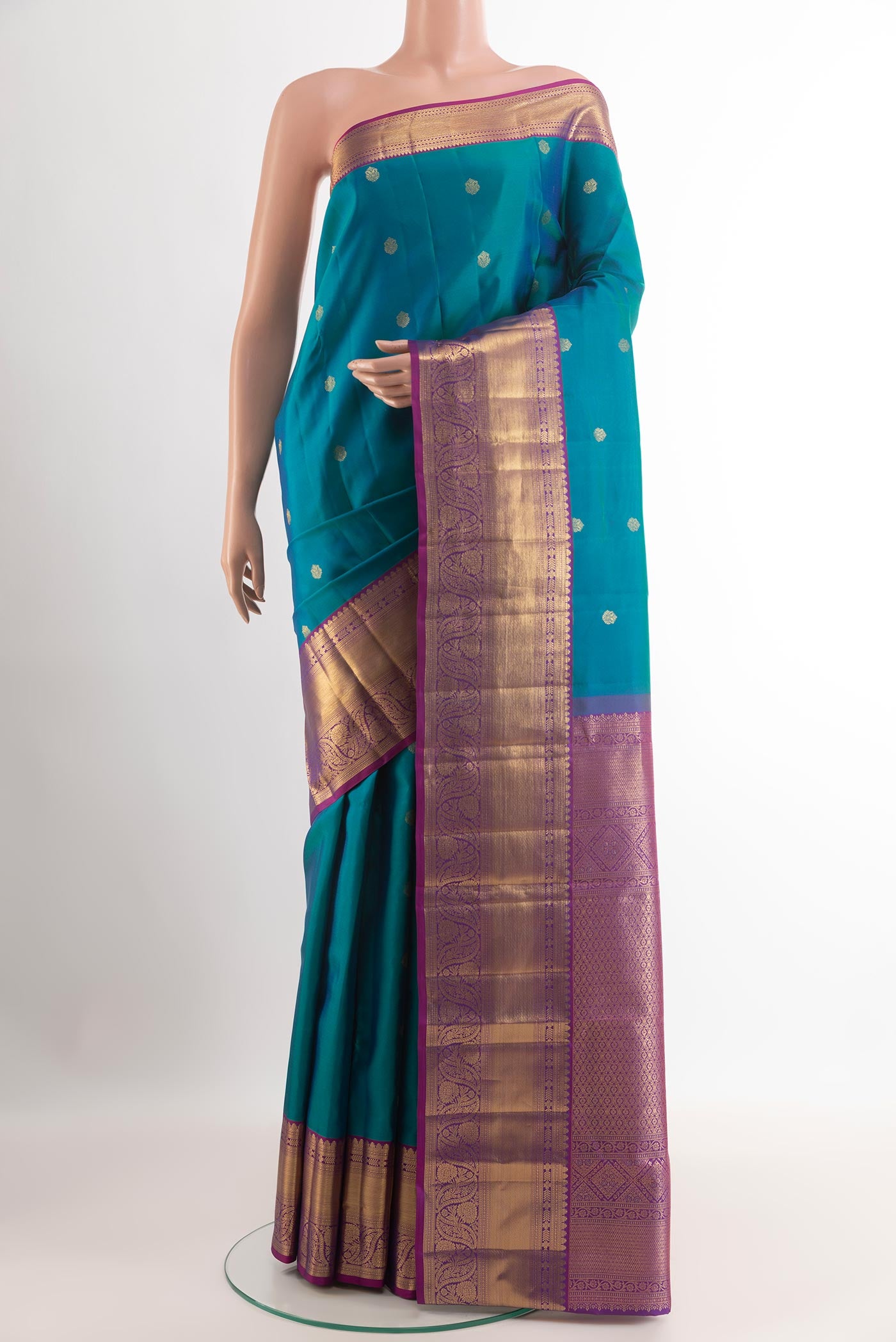 Peacock Blue Kanchipuram Silk Saree with Zari Butta on the body and Zari Border.  displayed on a mannequin