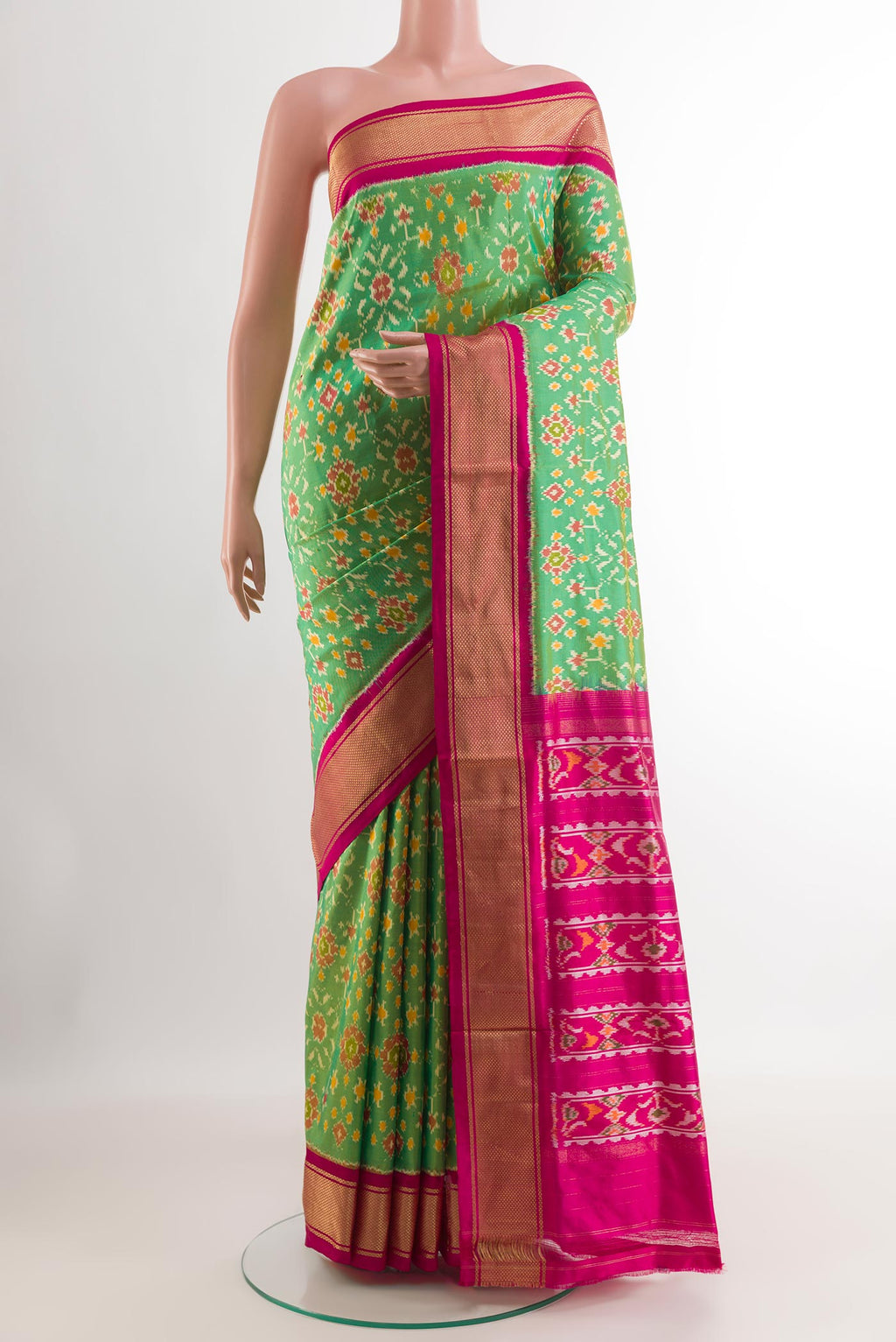 Green Pochampally Silk Saree with Ikat design on the body and Zari Border.  displayed on a mannequin